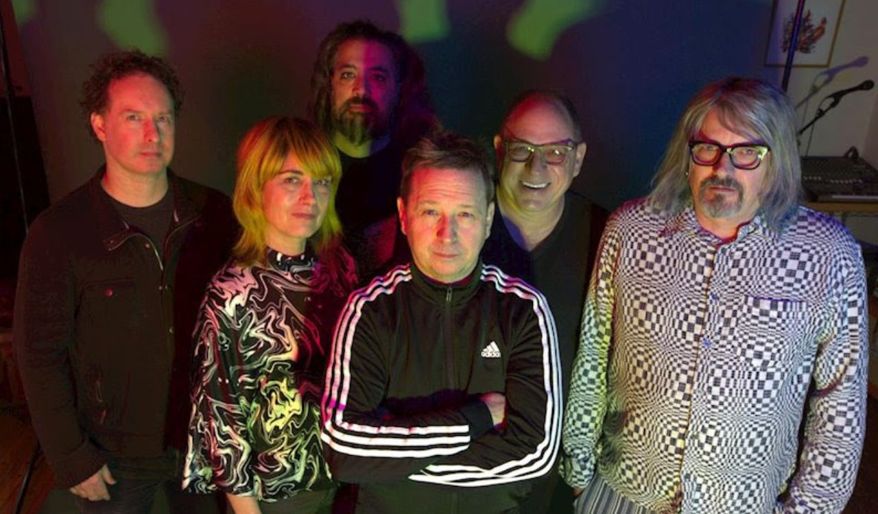 band standing in front of psychedelic background